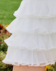Macro detail of Pom Pêche Spin™ Mille Tiered Skirt showing 4-layer lightweight fine tulle pleats with scalloped ruffle edges – cool-touch breathable fabric for tennis and active wear