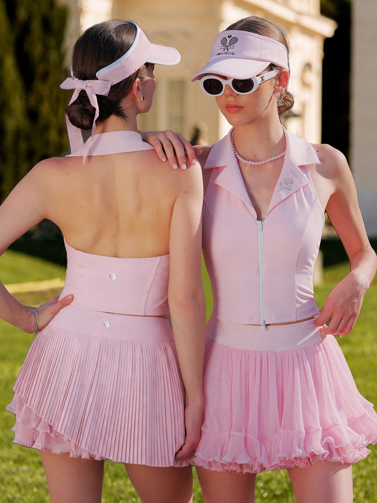 Pom Pêche Poise Rose Halter Polo Tank in pink – front and back view showing V-neck zipper front and open-back silhouette, styled with pleated tennis skirt and visor