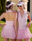 Pom Pêche Poise Rose Halter Polo Tank in pink – front and back view showing V-neck zipper front and open-back silhouette, styled with pleated tennis skirt and visor