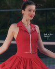 Pom Pêche Paris red Poise™ Rose Halter Polo Tank with Built-In Bra Support callout – model spinning showing polo collar, Pom Pêche rose embroidery and dual-zipper front, styled with wine red ruffle skirt on outdoor court