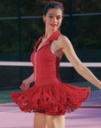 Side view of Pom Pêche Paris red Poise™ Rose Halter Polo Tank – open-back halter silhouette with dual-zipper open at waist, styled with wine red Rose Ruffle Skirt flaring in motion on outdoor tennis court