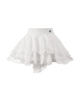 Flat lay of Pom Pêche Spin™ Petal Tiered Tennis Skirt in white – high-waisted band with Pom Pêche logo, three-tier asymmetric petal chiffon hem on white background