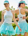 Pom Pêche Zip-Neck Halter Racerback Tank in white – front and back view showing high halter neckline with front zip and open racerback, model accessing back phone pocket, styled with mint tiered skirt in Paris garden
