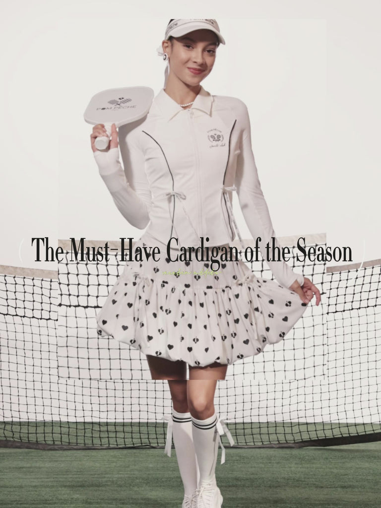 Black sun-protective tennis jacket with a sculpted fit, adjustable waist ties, and dual ball pockets.