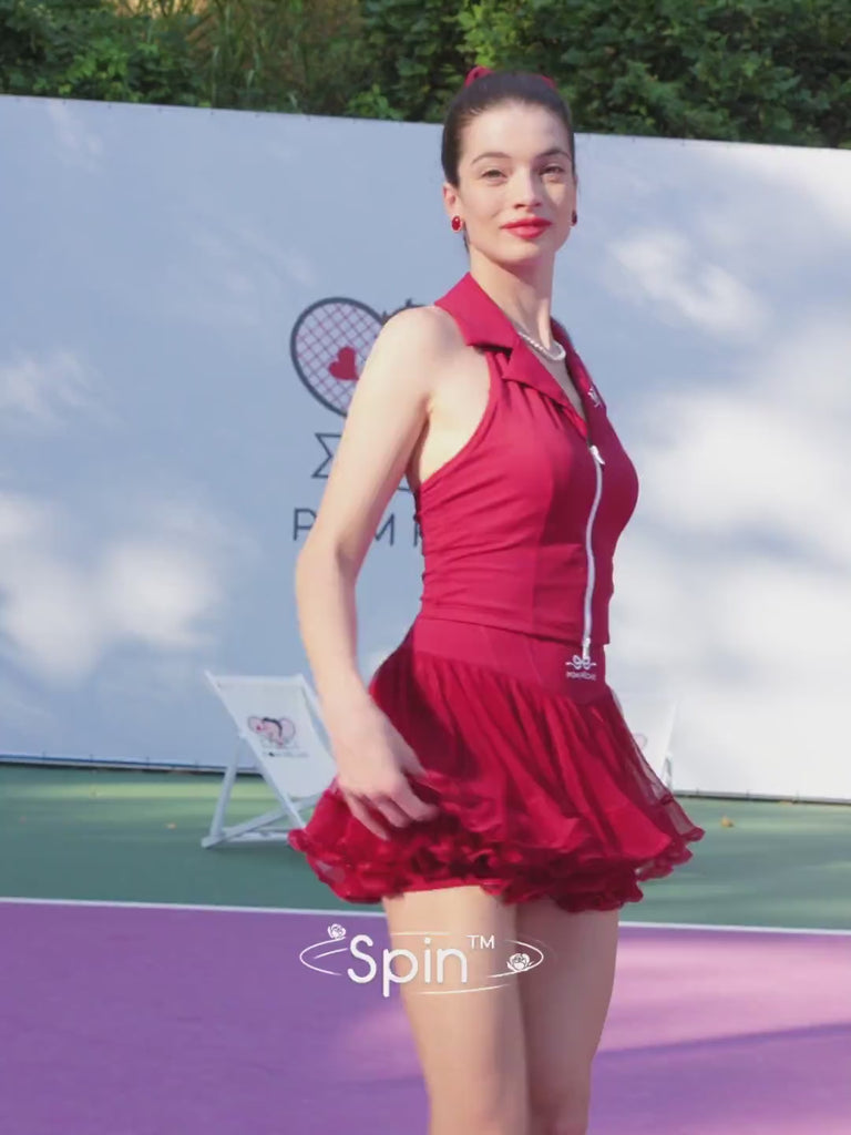 Pom Pêche Spin™ Rose Ruffle Skirt lookbook video – model spinning to showcase petal-like pleated mesh ruffle hem in tennis white, styled with matching white zip halter top on pink clay court