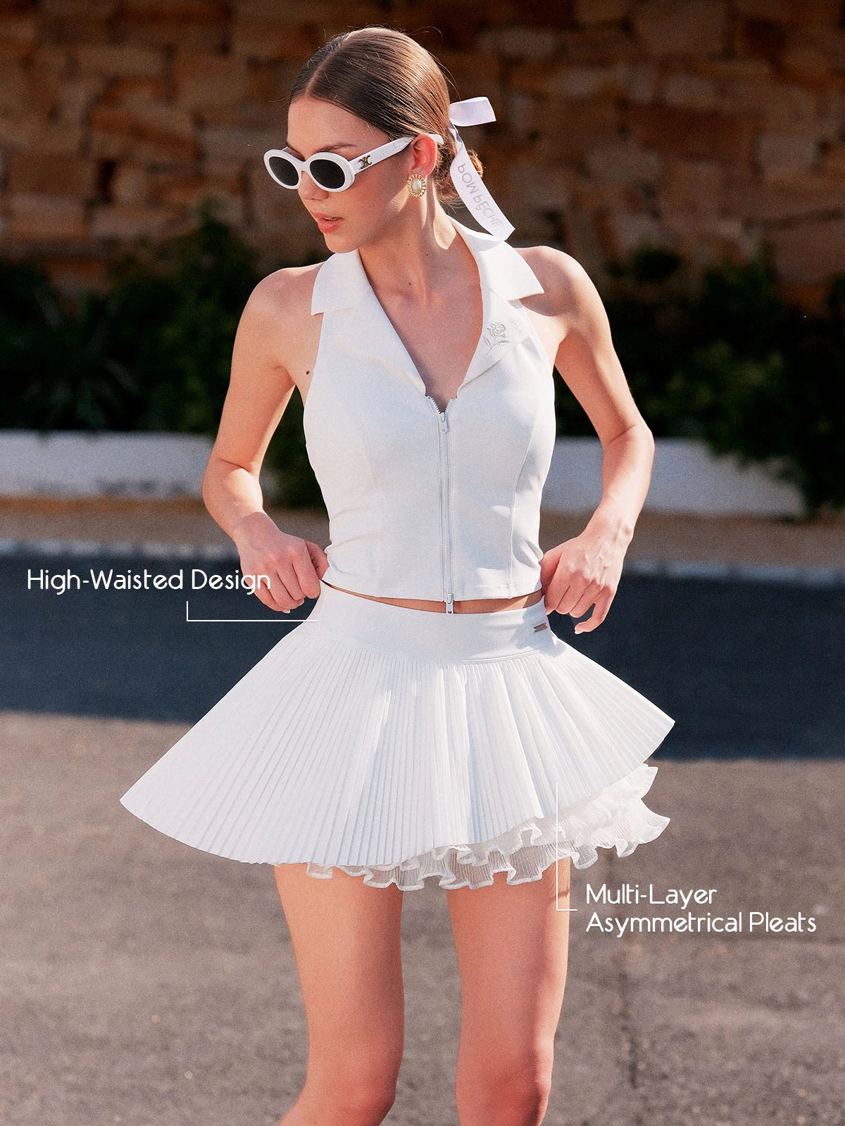 Spin Waltz Layered Tennis Skort White detail, showcasing high waisted waistband, asymmetric layered pleats, flattering silhouette, and elegant movement