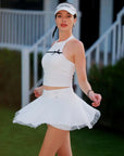 White Bow Halter Tennis Top dynamic side shot, flowing white tennis skirt mid-movement, UPF 50+ nylon athleisure by Pom Pêche