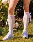 White knee-high socks with pink stripes and detachable bow front view