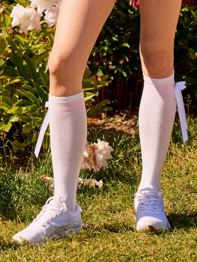 White knee-high socks with pink stripes and detachable bow front view