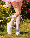 White knee-high socks with pink stripes and detachable bow on feet front view