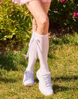 White knee-high socks with pink stripes, detachable bow, and non-slip stay-up design on feet