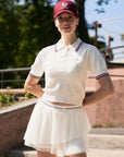 White cropped tennis polo top with oversized collar, puff sleeves, and breathable perforated knit